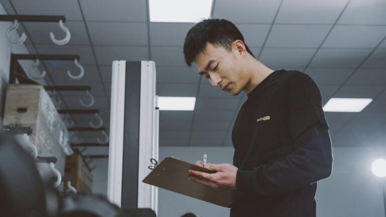 Warehouse staff member holding a clipboard checking stock