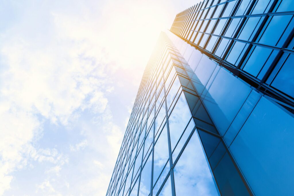 Glass curtain-wall office tower seen from below against the sky