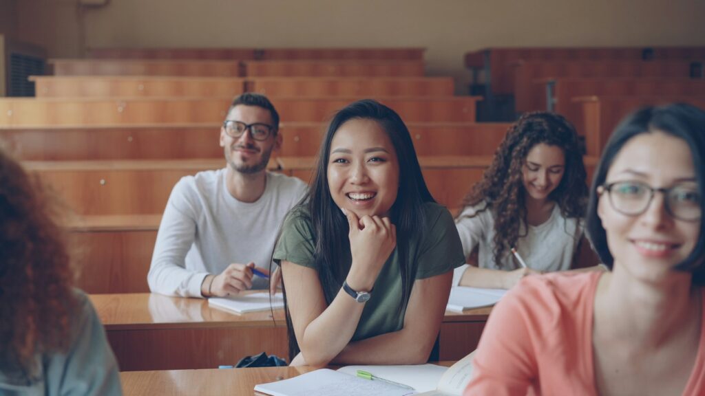 Students seated in a lecture hall listening to a teacher