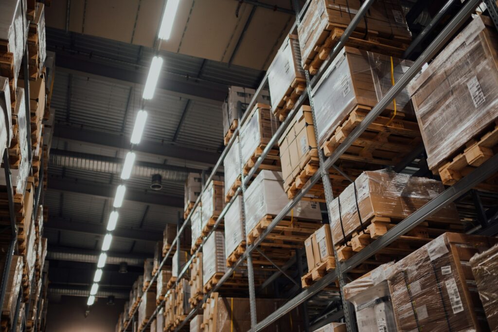 Stacked cardboard boxes on warehouse racking, organised by category